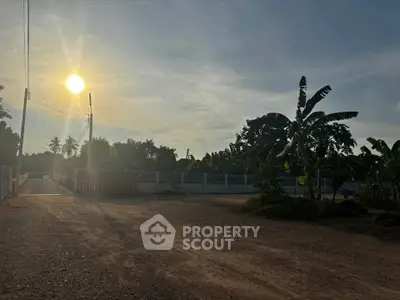 Expansive land plot with lush greenery and clear sky, perfect for development opportunities.