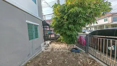 Spacious garden area beside modern residential building with lush greenery and ample sunlight.