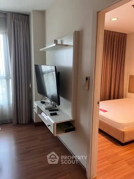 Modern apartment interior with sleek TV setup and cozy bedroom view.