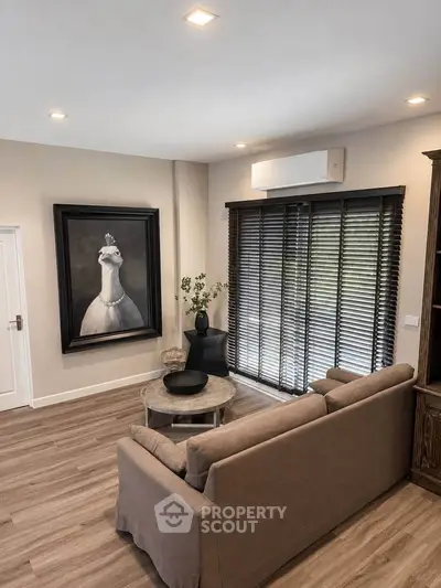 Stylish living room with modern decor and natural light, featuring a cozy sofa and elegant artwork.