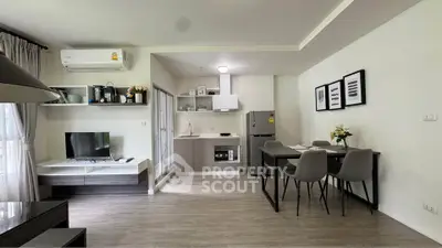 Modern open-plan living room and kitchen with sleek furniture and natural light.