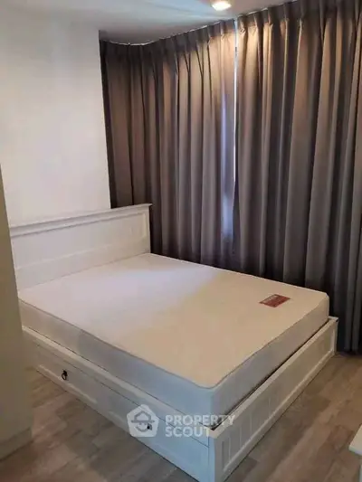 Cozy bedroom with elegant curtains and a comfortable bed in a modern apartment.