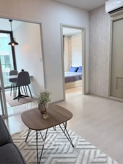 Modern living room with stylish decor and view into dining and bedroom areas
