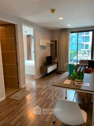 Modern apartment interior with open living space and balcony view.