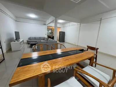 Spacious open-plan living and dining area with modern furniture and sleek design.