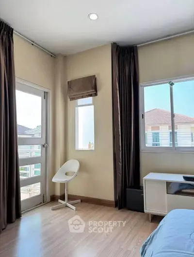 Bright bedroom with large windows and modern decor in a stylish home.