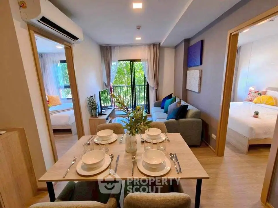 Modern open-plan living room with dining area and balcony view in a stylish apartment.