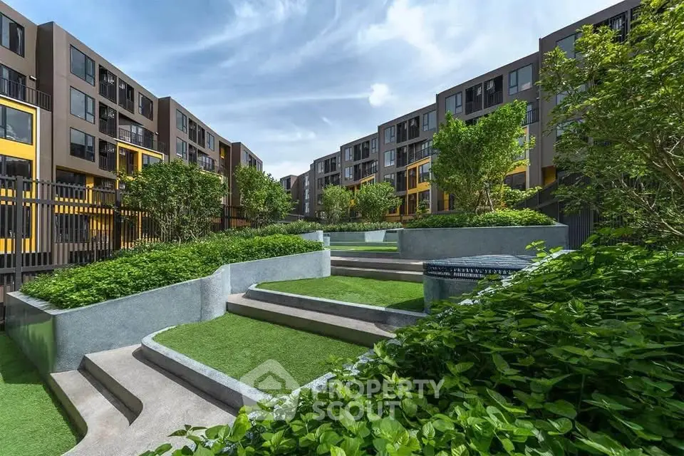 Modern apartment complex with lush landscaped gardens and contemporary architecture.