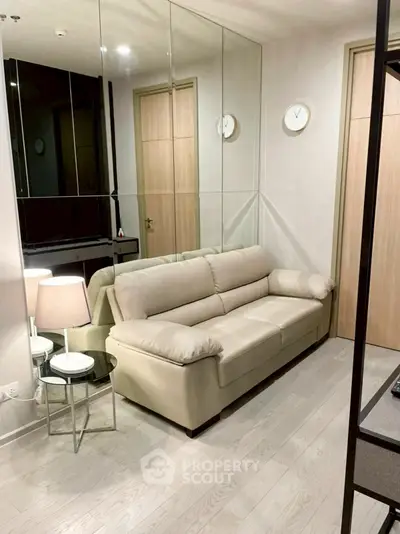 Modern living room with mirrored wall and beige sofa