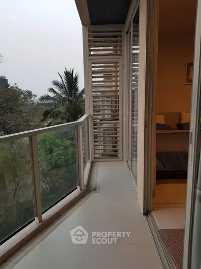Spacious balcony with serene garden view and bedroom access
