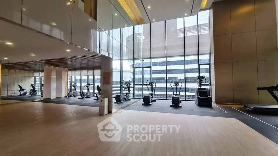 Luxurious gym with modern equipment and floor-to-ceiling windows offering stunning city views.