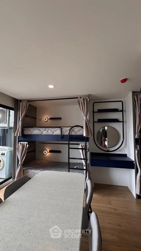 Modern interior with bunk beds and dining area, featuring sleek design and ample natural light.