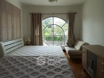 Spacious bedroom with large window and cozy seating area