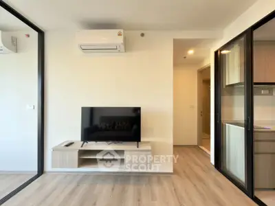 Modern living room with sleek TV setup and air conditioning in stylish apartment.