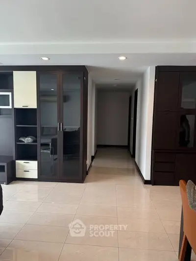 Spacious living area with modern cabinetry and sleek tile flooring in a contemporary apartment.