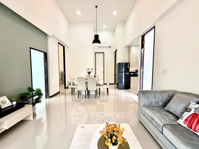 Spacious modern living room with elegant dining area and sleek kitchen appliances.