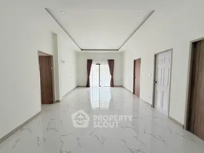 Spacious modern living room with elegant marble flooring and large windows for natural light.