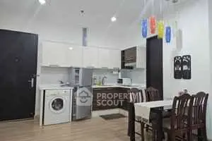 Modern kitchen with dining area and washing machine in stylish apartment.