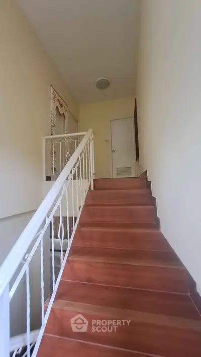 Charming stairway with wooden steps and elegant railing in a cozy home