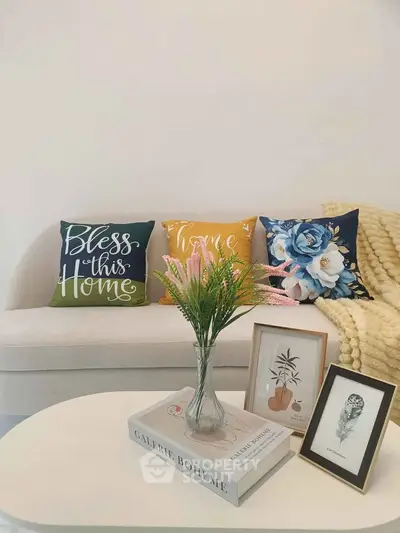 Charming living room with cozy sofa, decorative pillows, and elegant coffee table setup.