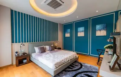 Modern bedroom with stylish blue accent wall and cozy lighting