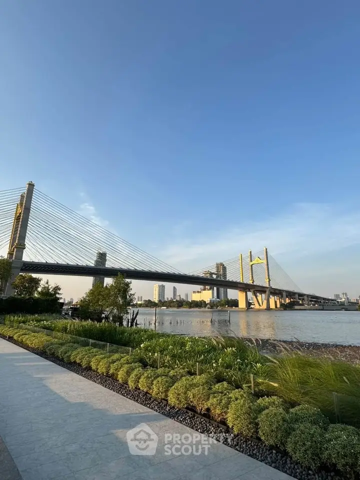 Stunning riverside view with modern bridge and lush greenery, perfect for urban living.