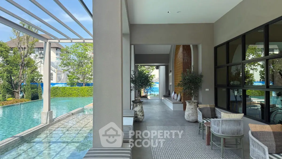 Luxurious poolside view with modern seating area and lush greenery, perfect for relaxation.