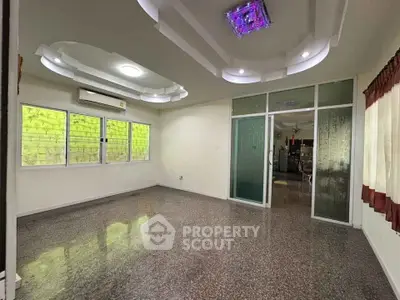 Spacious living room with modern ceiling design and large windows for natural light.
