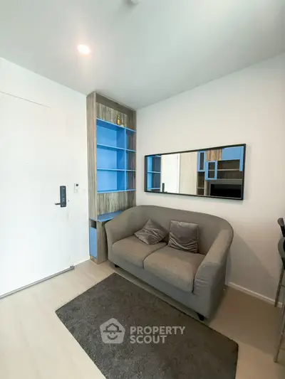 Cozy living room with modern sofa and built-in shelving, perfect for urban living.