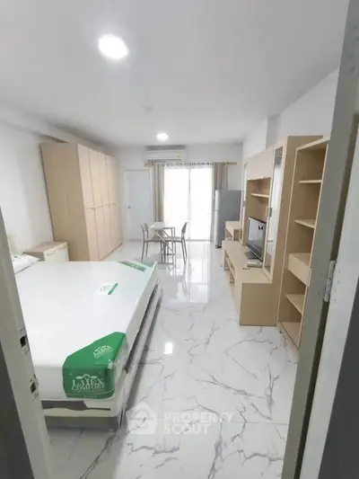 Spacious modern bedroom with marble flooring and stylish furniture in a bright apartment.