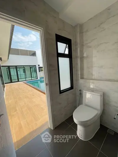 Modern bathroom with poolside view in luxury home