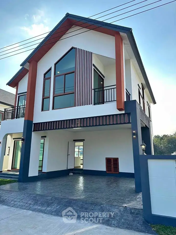 Modern two-story house with large windows and stylish exterior design.