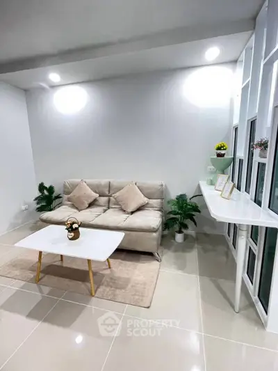 Modern living room with sleek sofa, stylish coffee table, and elegant decor in a bright, minimalist setting.