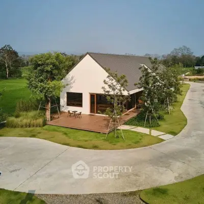 Charming modern house with spacious wooden deck and lush green surroundings, perfect for serene living.