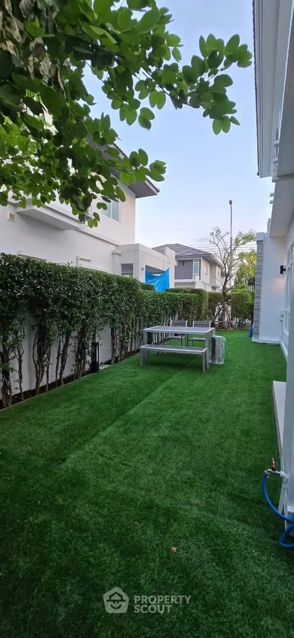Charming garden area with lush green lawn and outdoor seating, perfect for relaxation and entertaining.