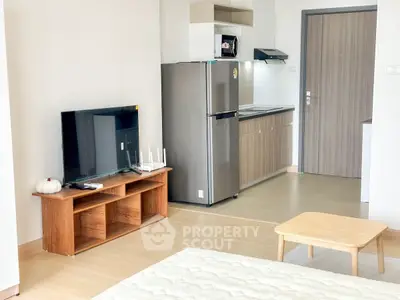 Modern studio apartment with sleek kitchen and cozy living area.
