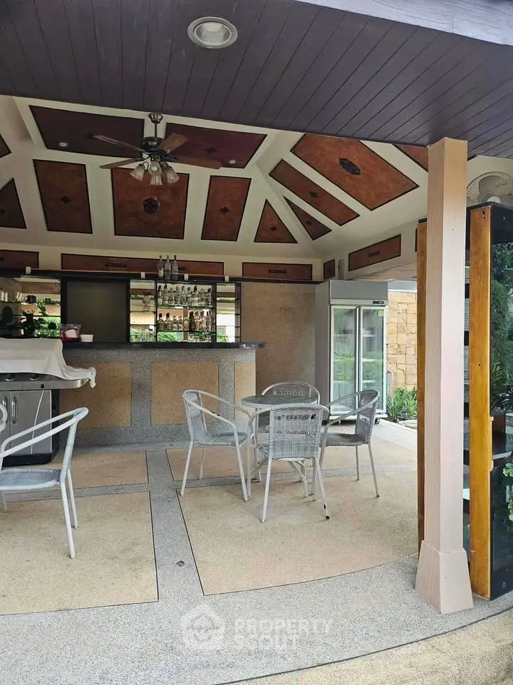 Charming outdoor patio with stylish bar and seating area, perfect for entertaining guests.