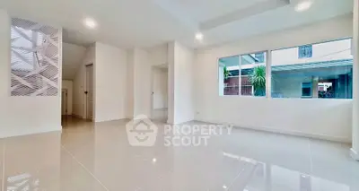 Spacious modern living room with glossy tile flooring and large window