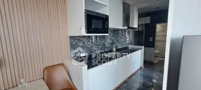 Modern kitchen with sleek design, featuring marble countertops and built-in microwave for stylish living.