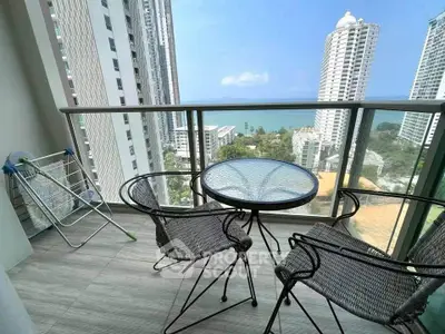 Stunning balcony view with modern furniture overlooking the ocean and cityscape.