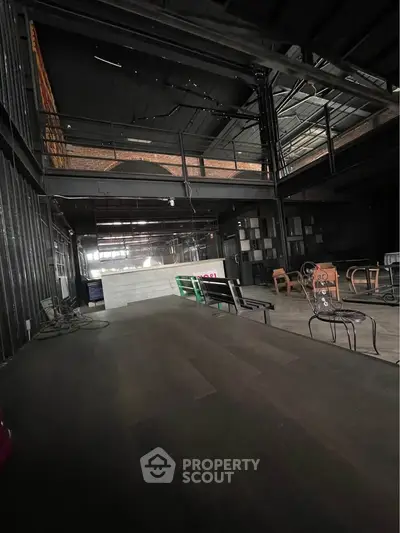Spacious industrial-style interior with mezzanine and modern furnishings.