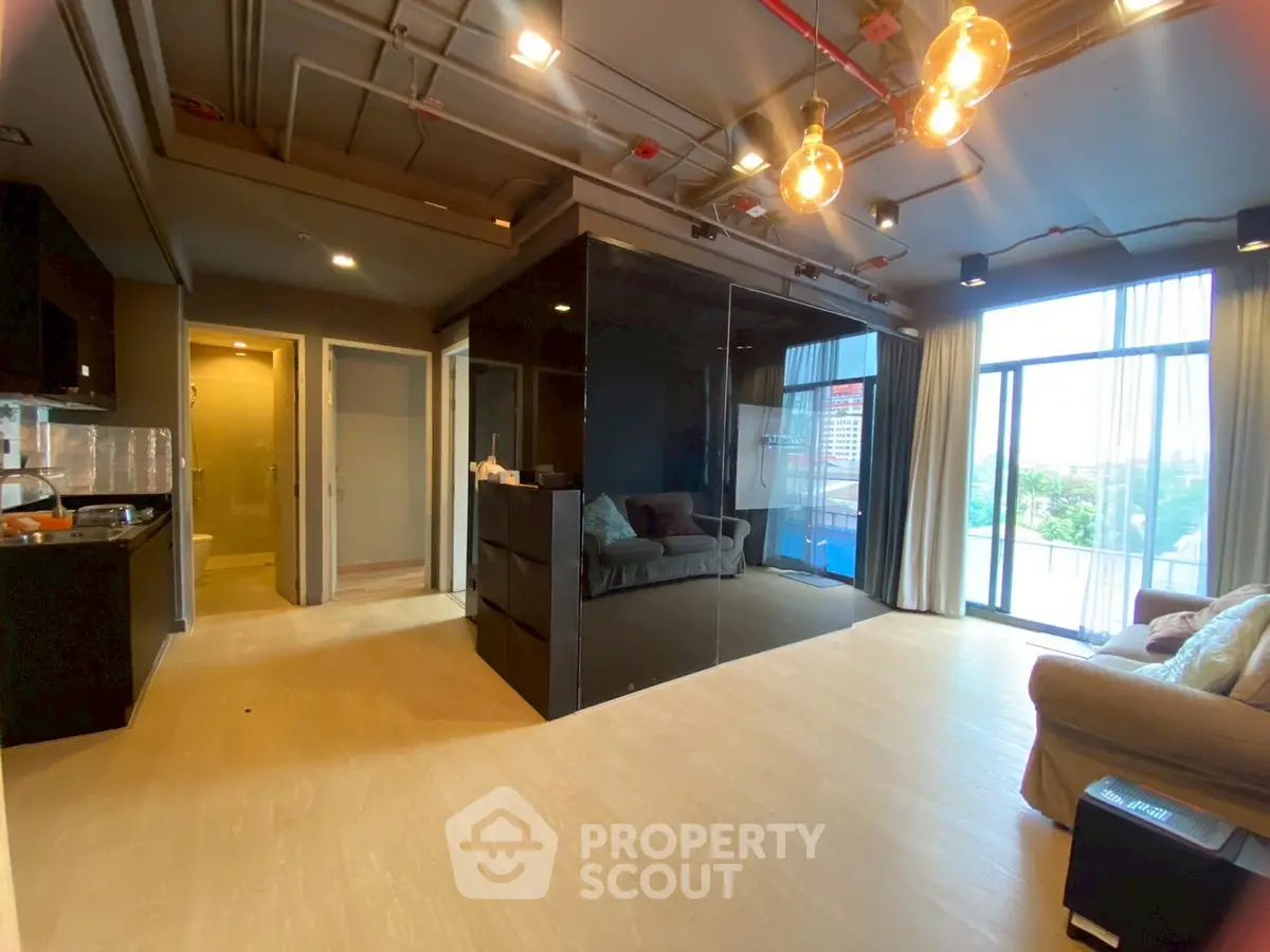 Modern living room with large windows and stylish lighting in a contemporary apartment.