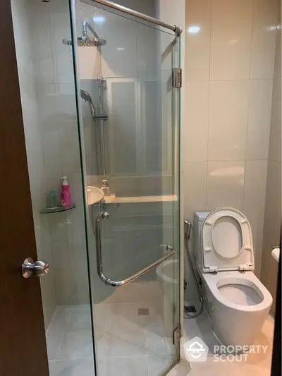 Pristine modern bathroom with glass shower enclosure and sleek fixtures, offering a clean and refreshing space for personal care routines.