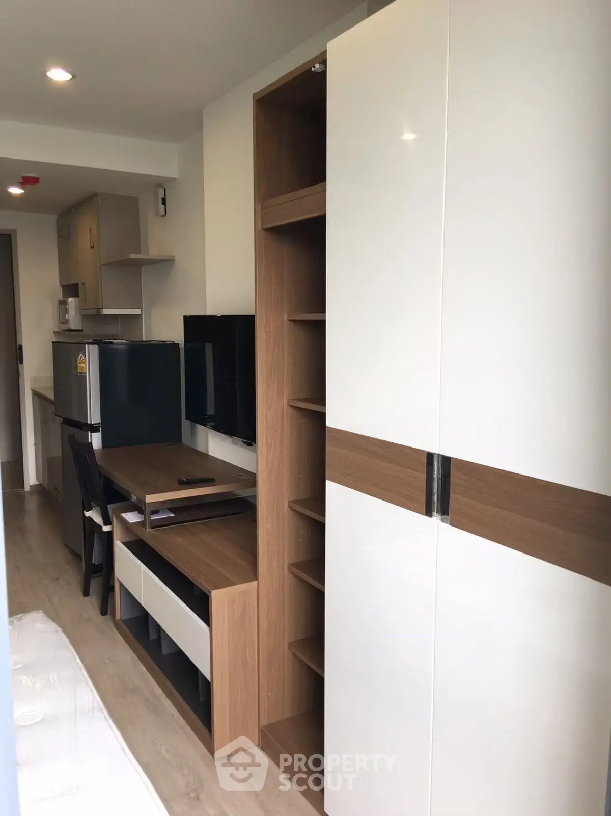 Modern compact living room with sleek furniture and integrated storage solutions.