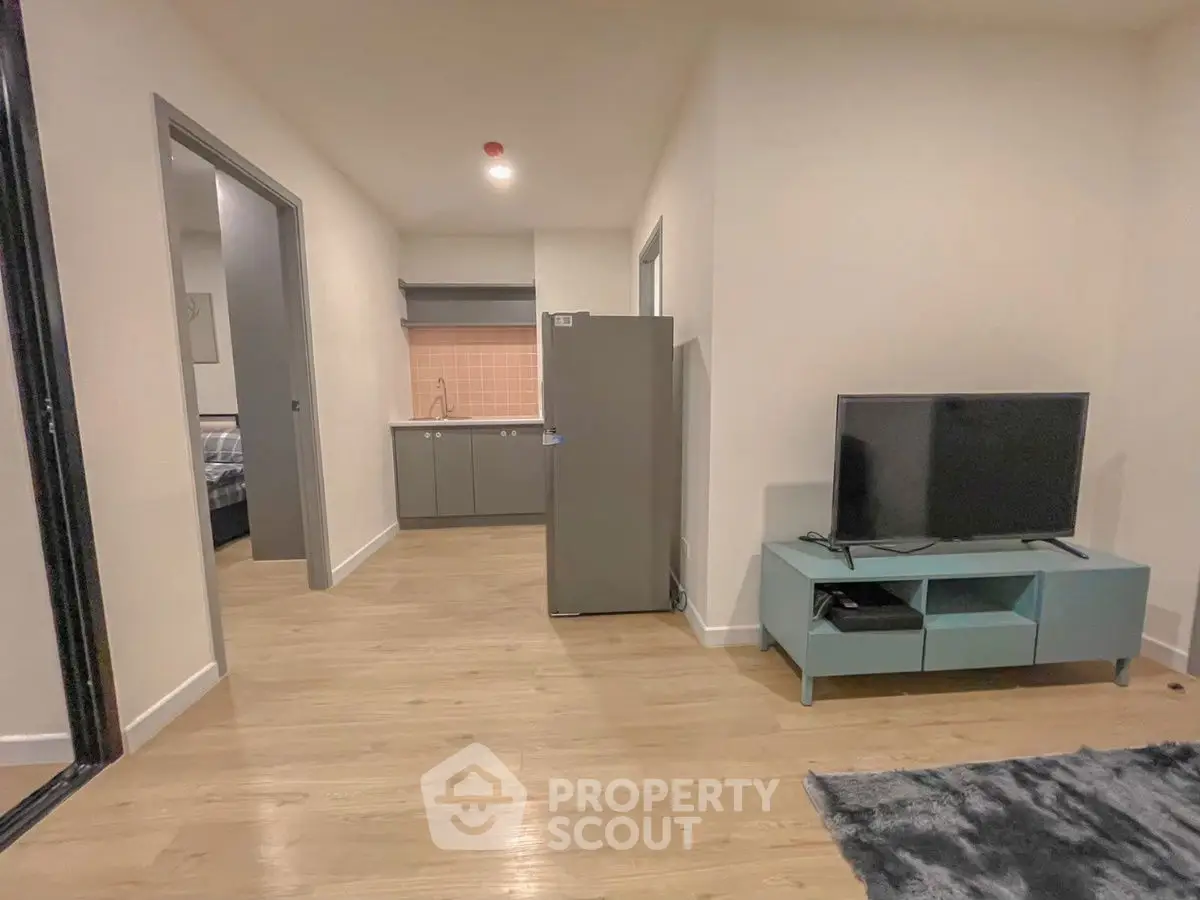 Modern apartment interior with open layout, featuring a cozy living area and compact kitchen.