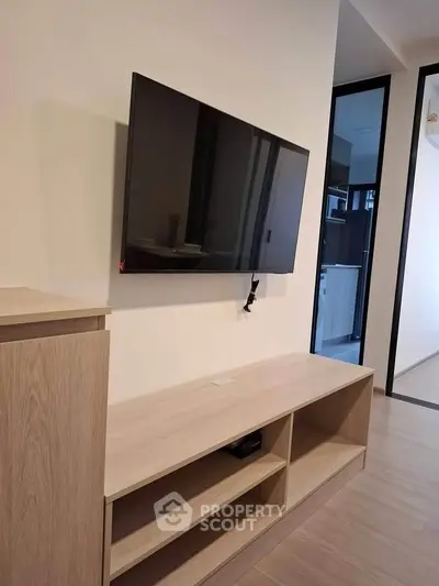 Modern living room with wall-mounted TV and sleek wooden furniture, perfect for contemporary urban living.