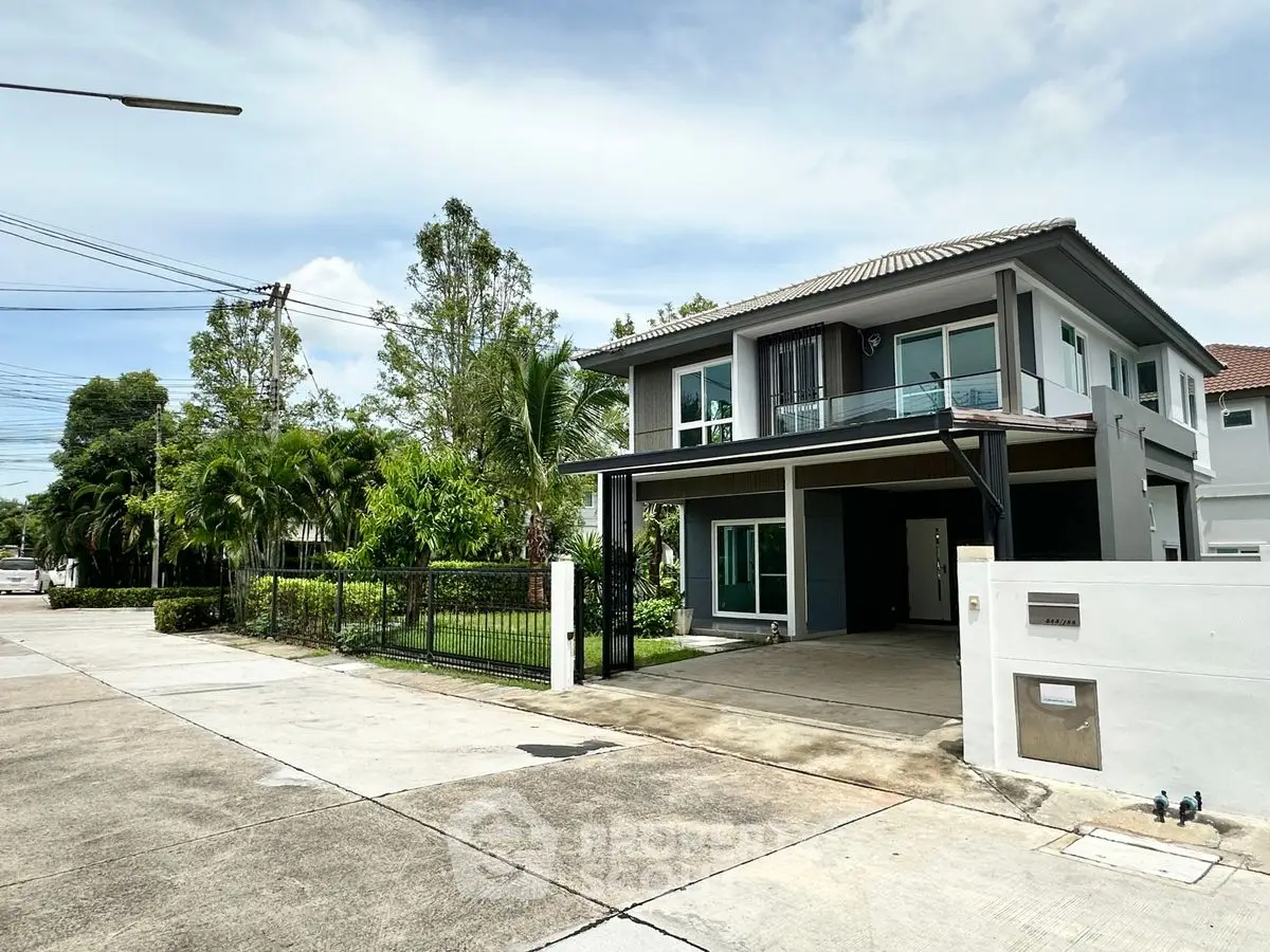 Modern two-story house with spacious driveway and lush greenery in a serene neighborhood.