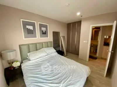 Cozy bedroom with modern decor and ensuite bathroom in a stylish apartment.