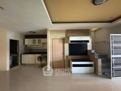 Spacious modern living area with open kitchen and staircase, ideal for family gatherings.