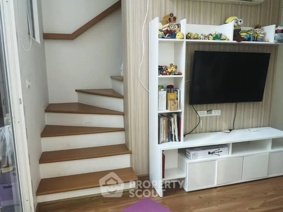 Charming living room with modern staircase and entertainment center, perfect for cozy family gatherings.